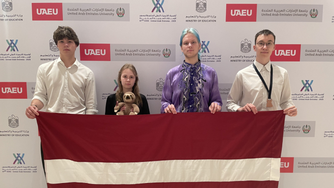 Latvijas komandas dalībnieki rokās ar LV karogu ķīmijas olimpiādē 2025 Dubaijā