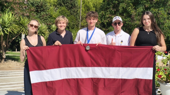 Latvijas komandas dalībnieki ar karogu ekonomikas olimpiādē Griekija