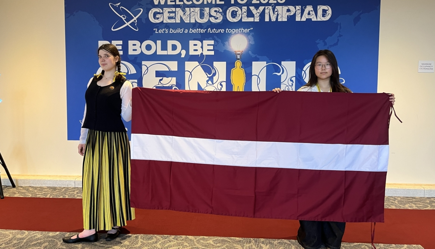 Genius Olympiad Latvijas pārstāves ar LV karogu 