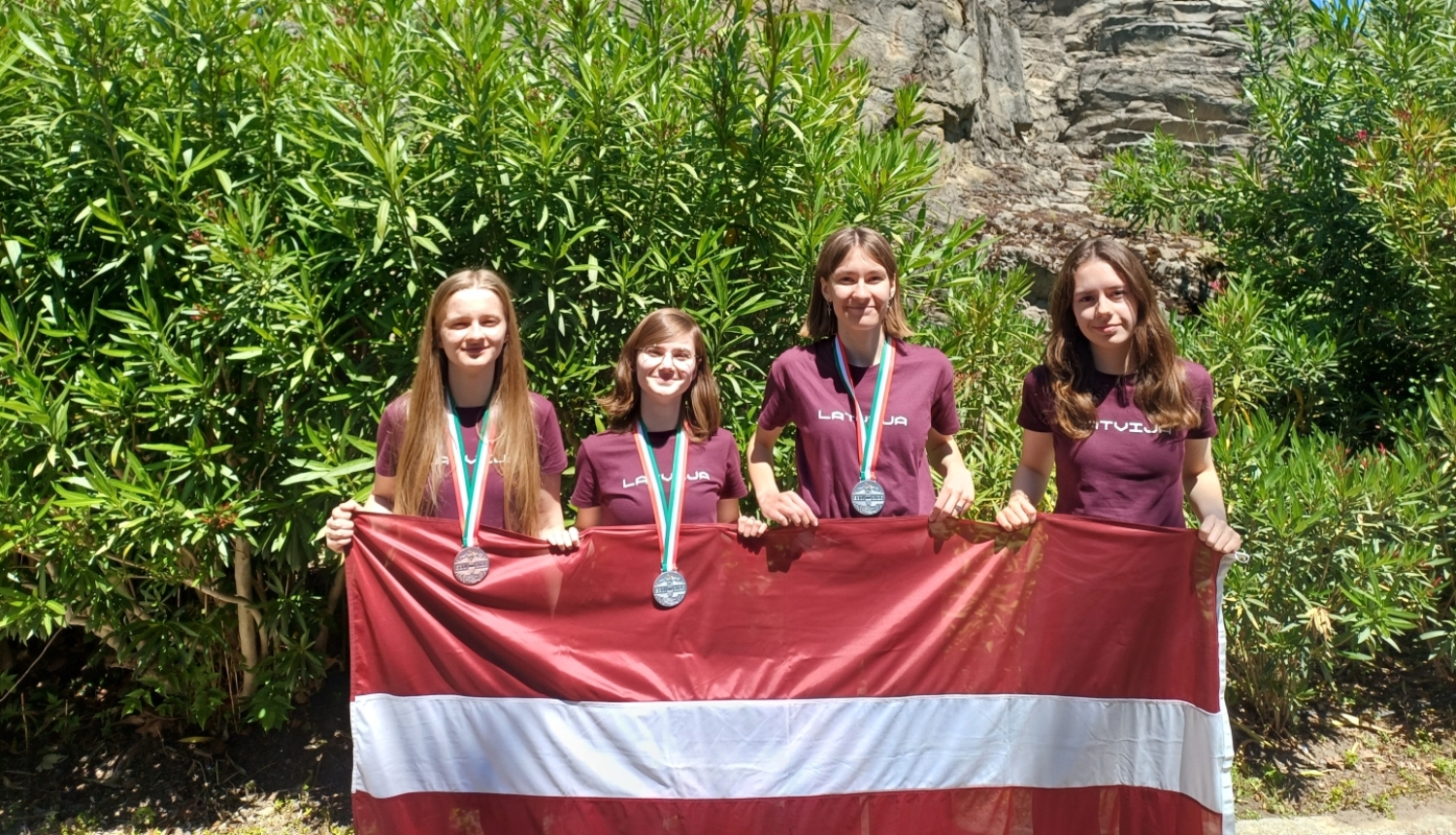 informatikas olimpiade Čezantiko, Itālijā, dalībnieces no Latvijas ar LV karogu 
