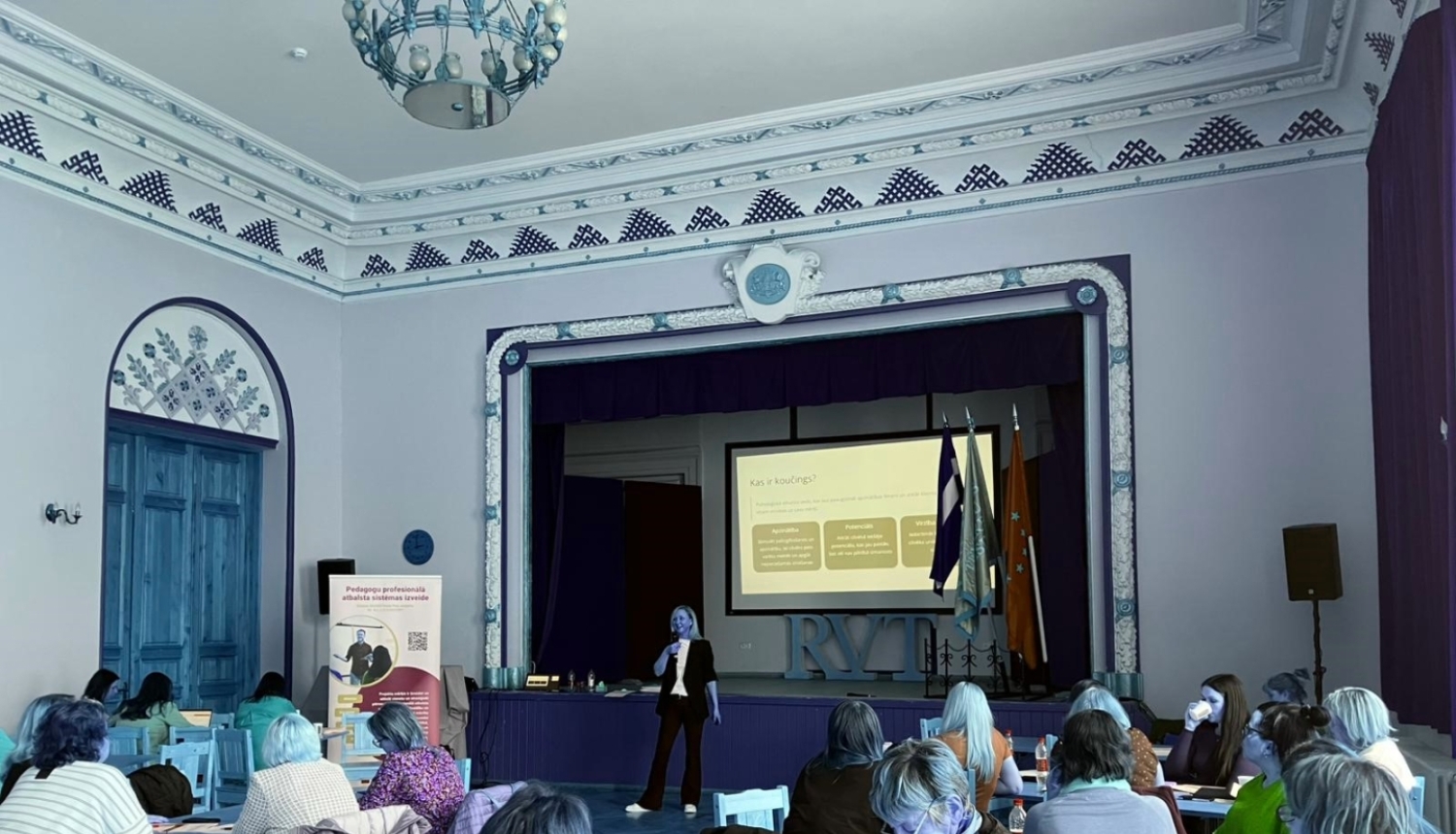 Profesionālās izglītības pedagogi mācās, pedagogi sēž pie galdiņiem, lektors priekšā runā