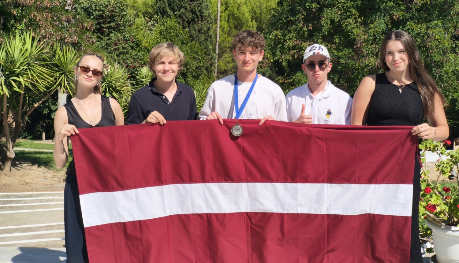 Latvijas komandas dalībnieki ar karogu ekonomikas olimpiādē Griekija