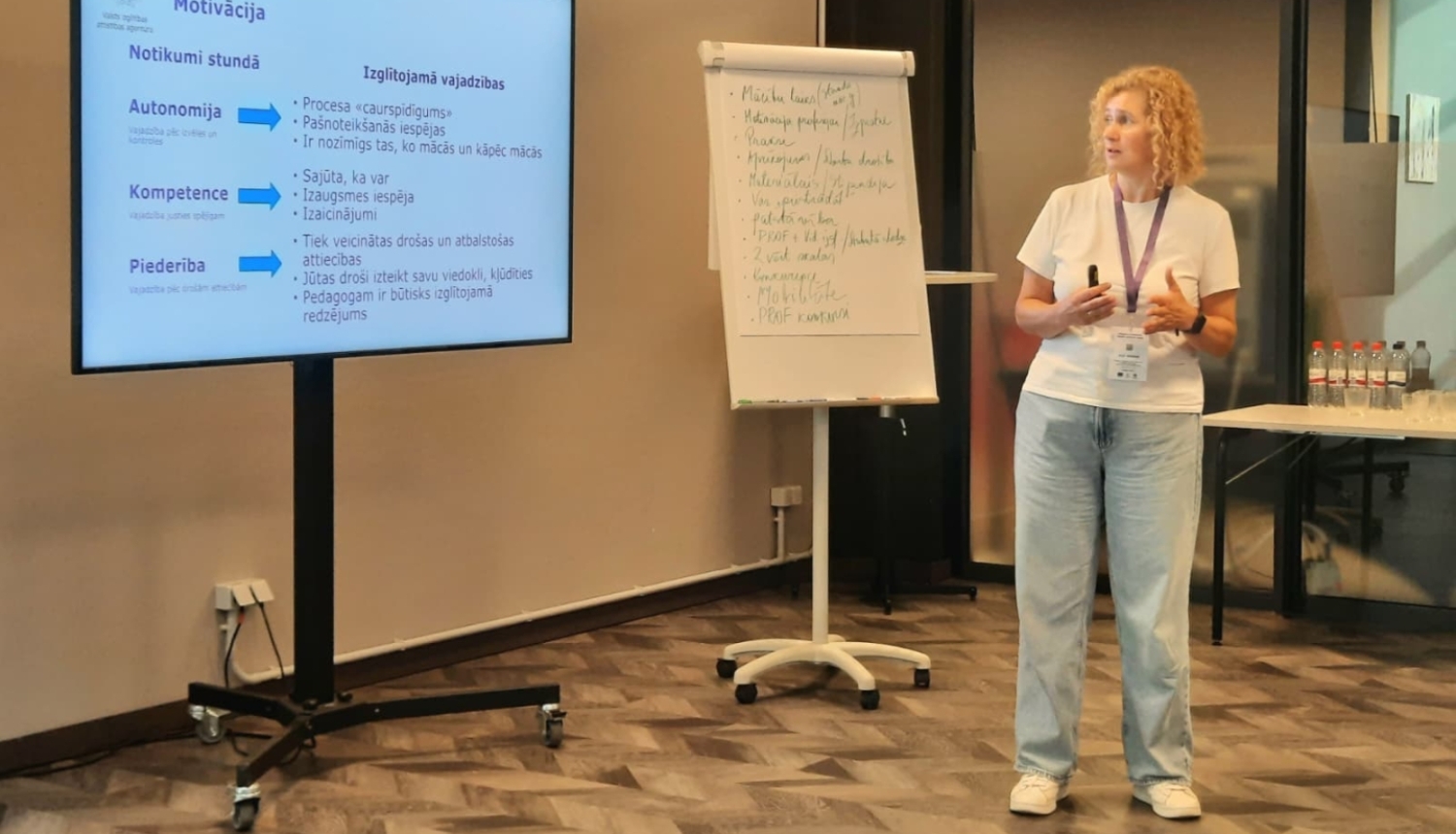VIAA pārstāve stāv pie tāfeles seminārā pedagogiem 