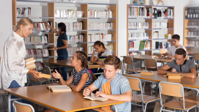 attēlā skolotāja klasē kopā ar skolēniem 