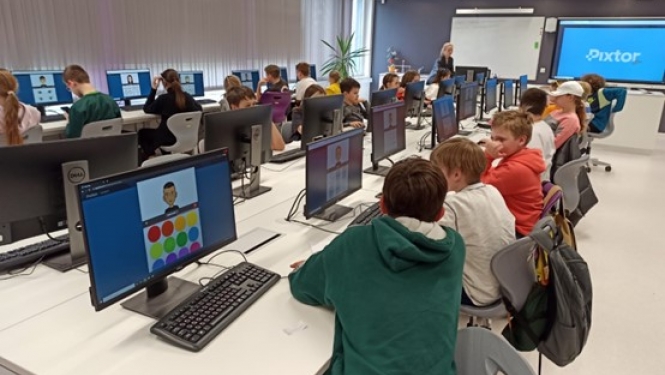 Skolēni sēž pie datoriem klasē