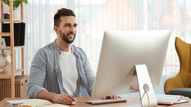 Vīrietis raksta ar portatīvo datoru