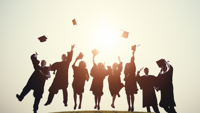 Erasmus studenti priecīgi lec un met gaisā absolventu cepures
