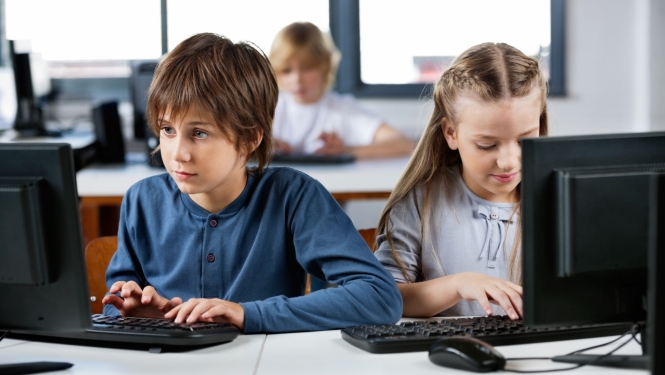 puika un meitene sez pie datora klase