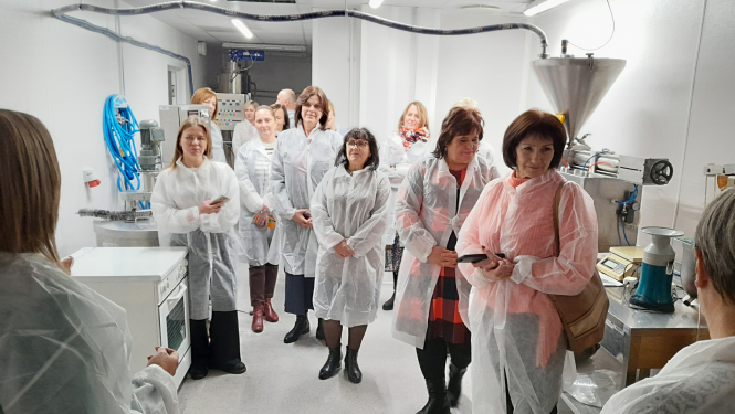 Cilvēki stāv ražošanas telpās