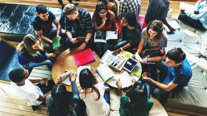 Cilvēku grupa sēž pie galda