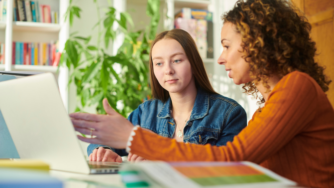 Sievietes diskutē pie datora