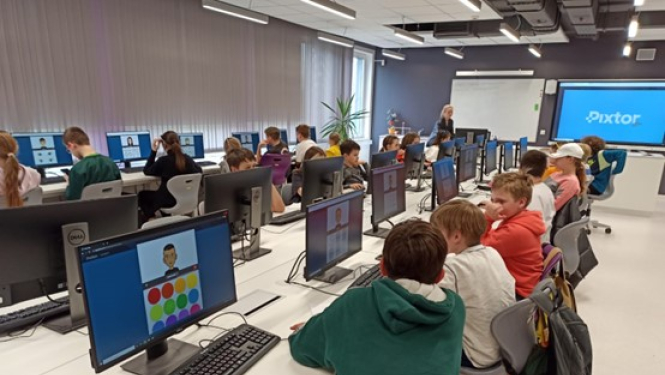 Skolēni sēž pie datoriem klasē