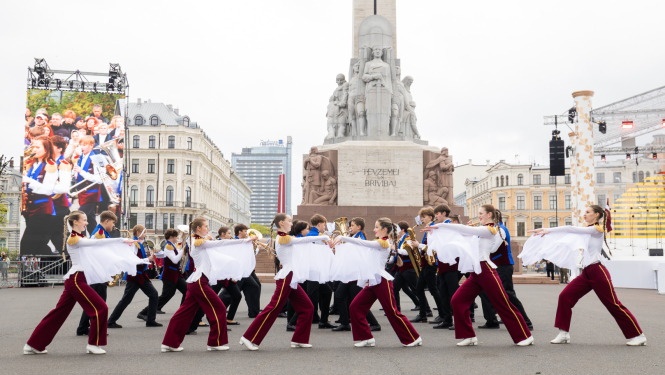 attēlā dalībnieki piedalās Latvijas skolēnu pūtēju orķestru defile pie Brīvības pieminekļa