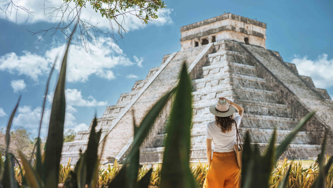 Jauna meitene skatās uz piramīdas celtni Meksikā