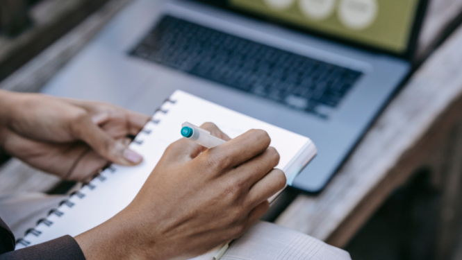 Cilvēks raksta bloknotā