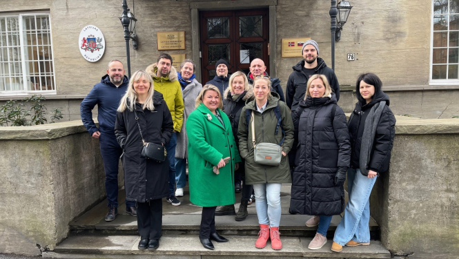 Cilvēku grupa stāv uz kāpnēm