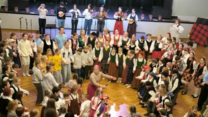 Bērni iet tautiskās rotaļās