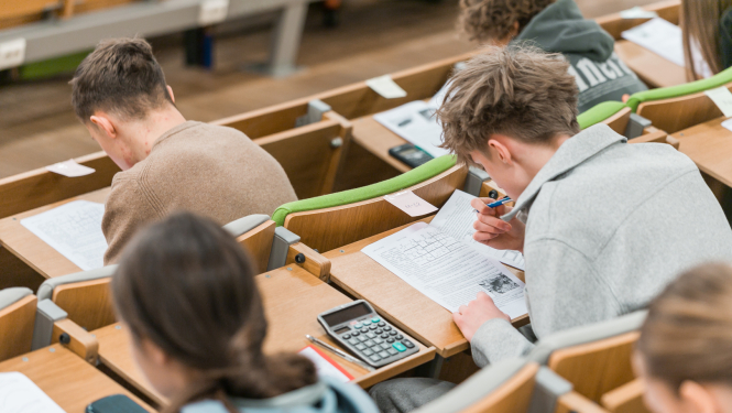 studenti sez auditorijā, pieraksta materiālu