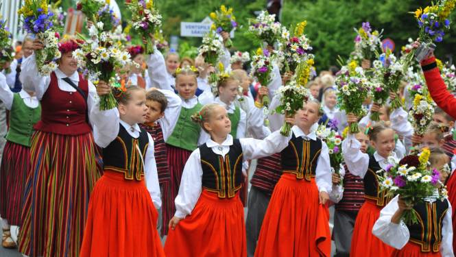 Bērni taututērpos ar ziediem rokās