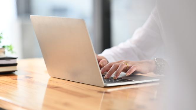 sieviete raksta uz portativā datora klaviaraturas 