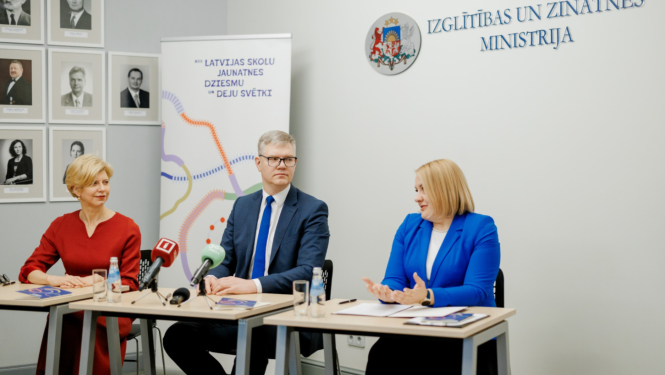 Cilvēki preses konferencē sēž pie galda un runājas