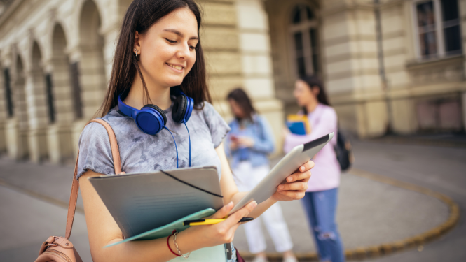 Jauniete priekšplānā smaida un skatās bloknotā 