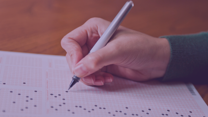 rokā tur pildspalvu un pilda testu uz lapas