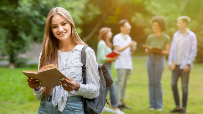 meitene ar grāmatu rokās brīvā dabā
