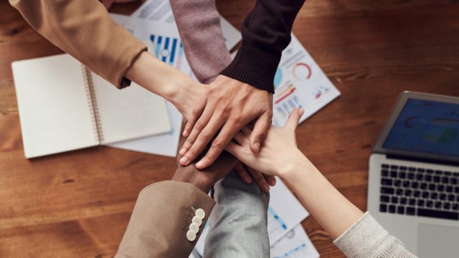 Cilvēki salikuši rokas vienu virs otras