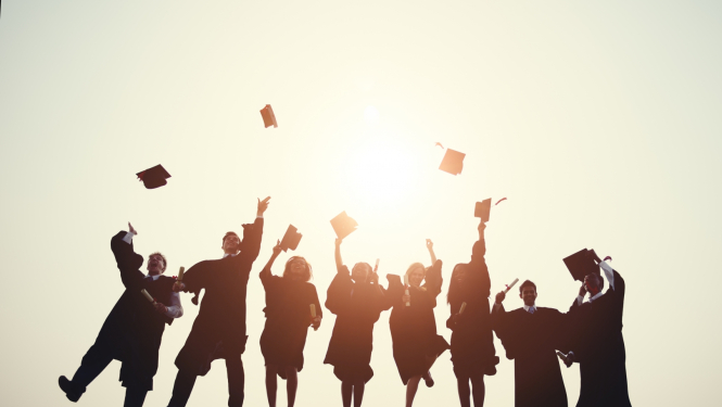 Erasmus studenti priecīgi lec un met gaisā absolventu cepures