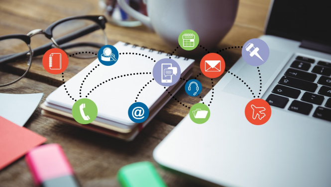 darba pierakstu klade uz galda blakus atvērts portatīvais dators virsūbildei ir aplīšos saliktas dažādas ikonas