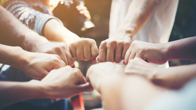 vairāki cilvēki salikuši dūrīšus vienotā aplī