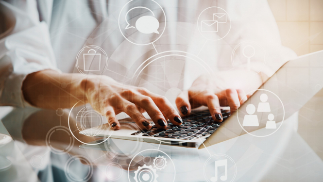 sievietes rokas drukā kaut ko uz portatīvā datora klaviaratūras aprārt datoram ir dažādas ikonas