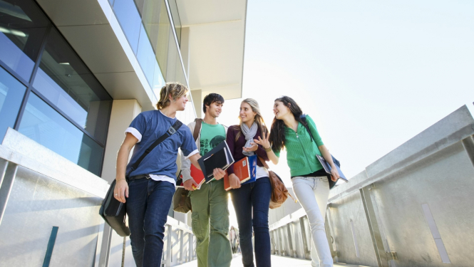 četri jaunieši iet pa ielu un sarunājas savā starpā