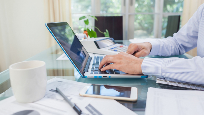 virietis raksta uz klaviaraturas pie portativa datora