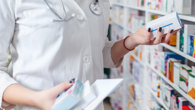 farmaceite tur rokās dažādus medikamentus aptiekā