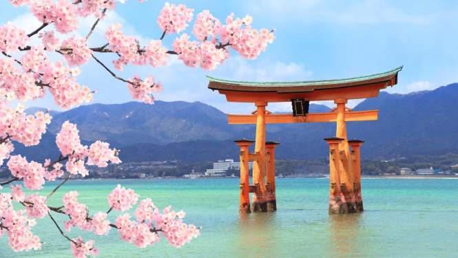 skats uz Japānas kalniem ar ezeru priekšplānā ziedošās sakuras zariņi