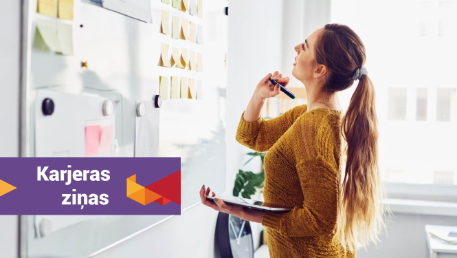 jauna sieviete stāv ar zīmuli un piezīmju lapām pie tāfeles, uz attēla rakstīts karjeras ziņas