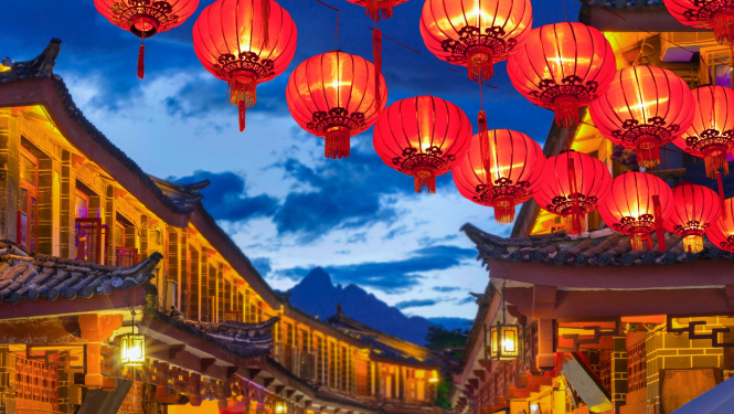 Ķīnas pilsētas ielas ainava ar laternām un kalniem fonā