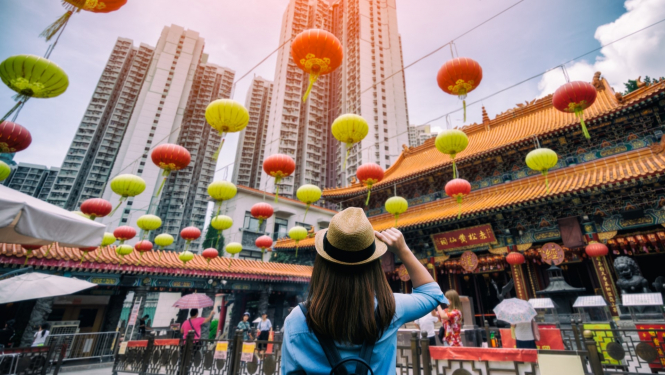 skats uz Ķīnas ielu ar ķiniešu laternām jauna meitene stāv ar muguru skatās uz laternām