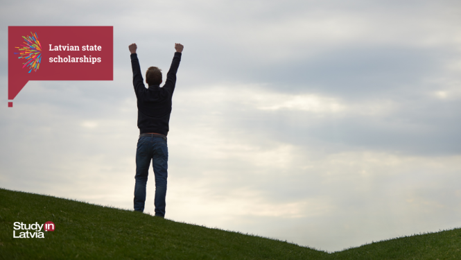 Stipendijas priecīgs jaunietis pļavā