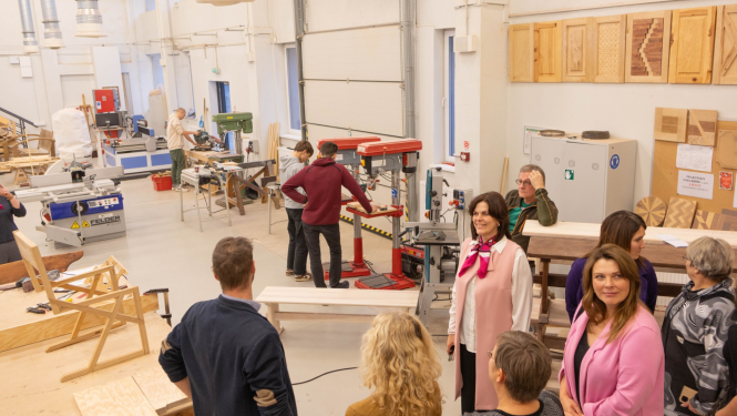 Cilvēku grupa kokapstrādes telpās