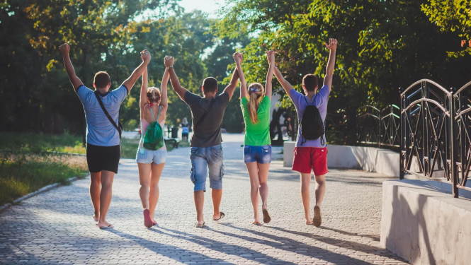vasaras skolas studenti priecigi soļo pa ceļu