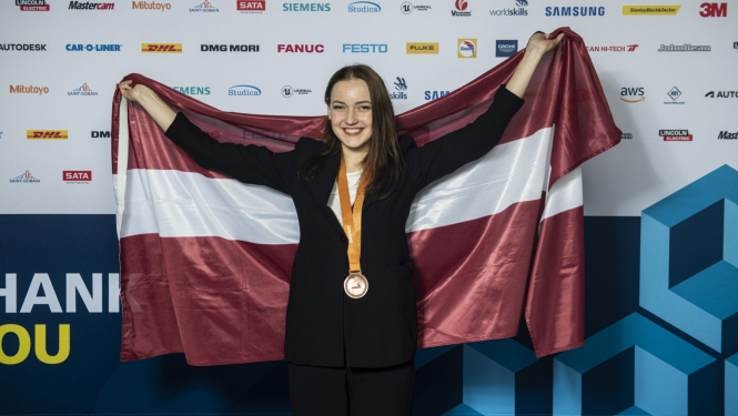 WorldSkills 2022 bronzas medaļas ieguvēja Kitija Kozule ar Latvijas karogu Stokholmā