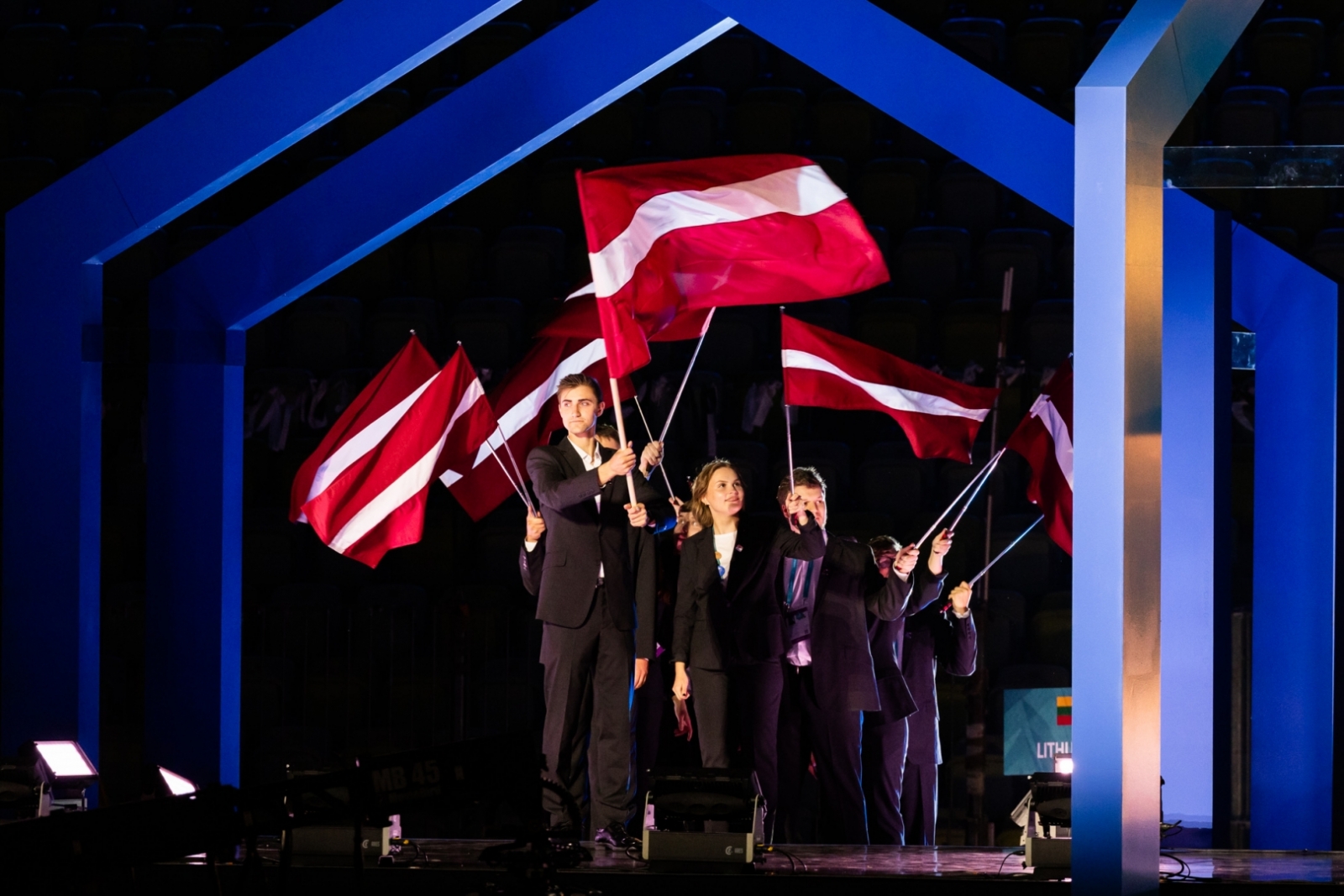 Atklāšanas ceremonija ar Latvijas komandu, kas rokās tur Latvijas karogus