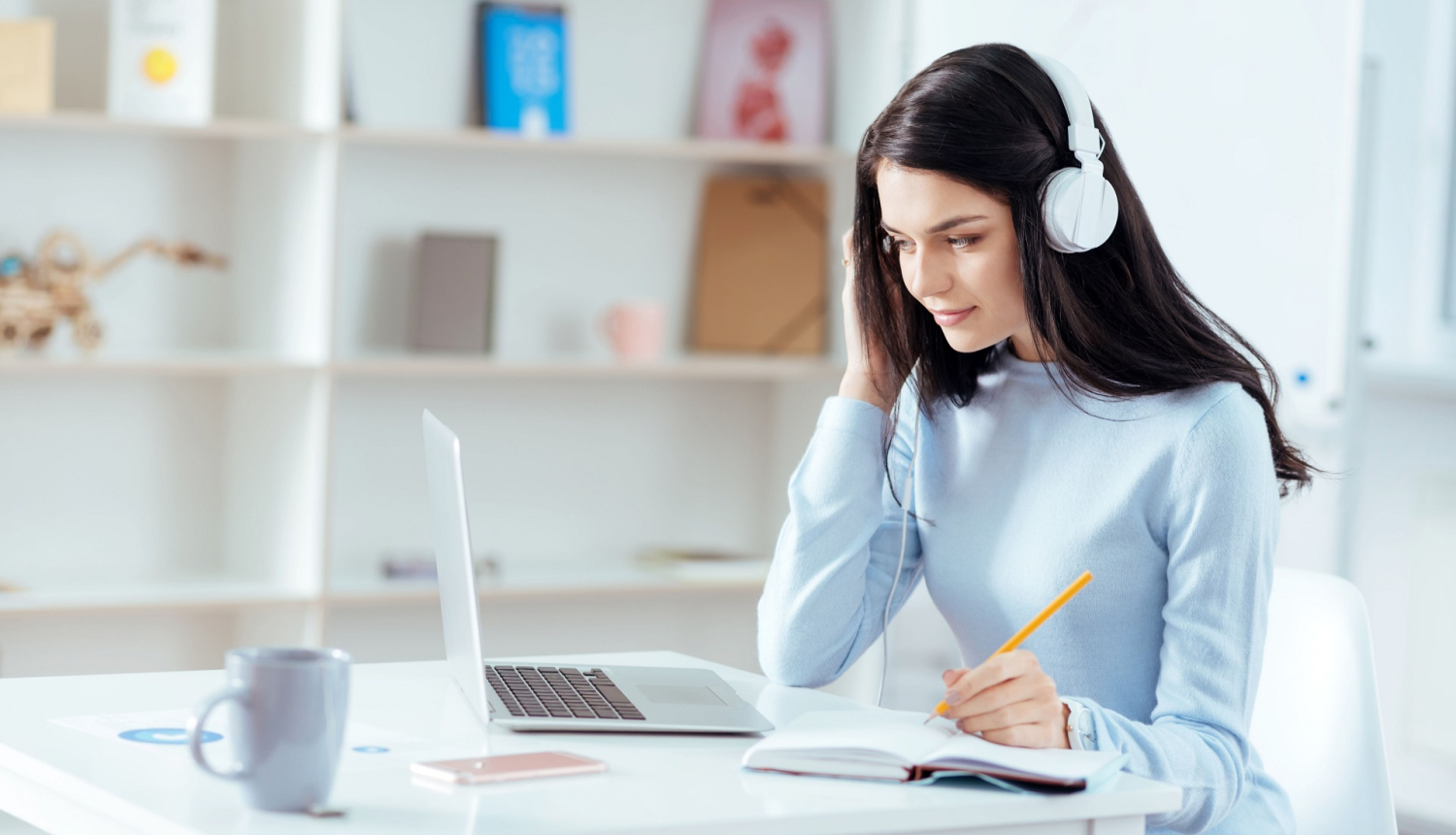 Sieviete skatās un klausās tiešsaistes semināru pie datora