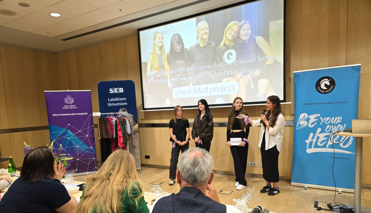 Jaunas meitenes prezentē projektus žūrijas priekšā