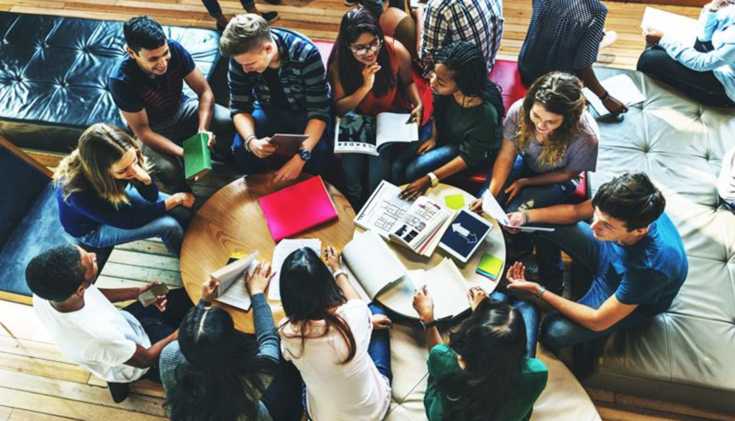 Cilvēku grupa sēž pie galda