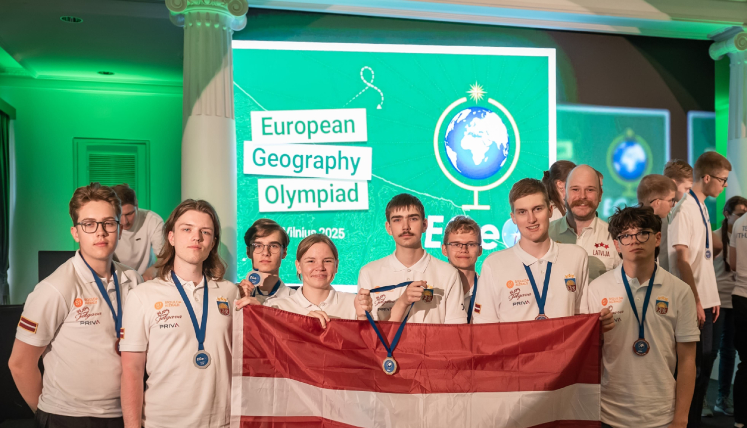 Latvijas komanda Ģeogrāfijas olimpiādē 2025 ar LV karogu