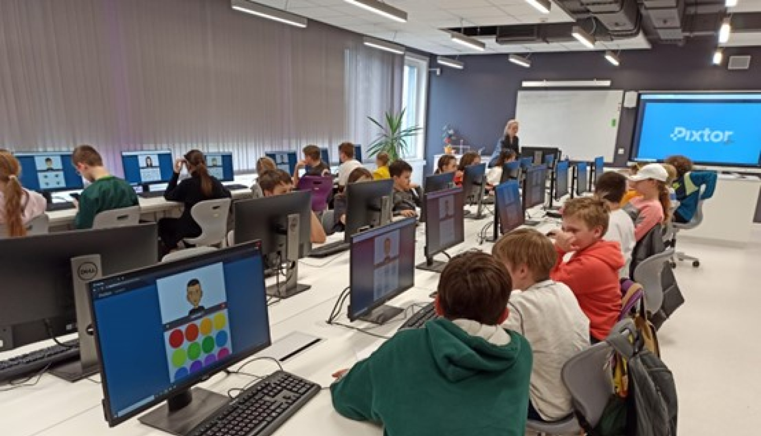 Skolēni sēž pie datoriem klasē